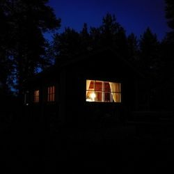 Illuminated house against sky at night