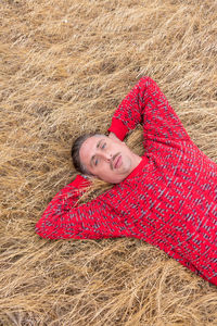 Portrait of smiling young woman lying on field