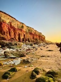 Scenic view of rocks in sea against clear sky