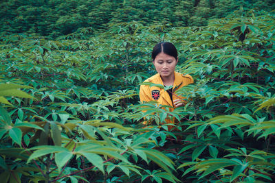 Woman standing amidst leaves on field