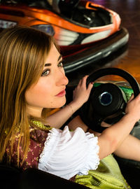 Beautiful woman in bumper car at amusement park during oktoberfest