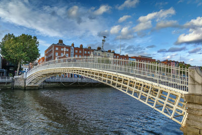 Arch bridge over river amidst buildings in city