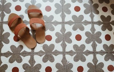 High angle view of sandals on patterned tiled floor