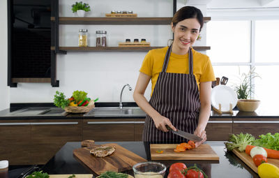 Young woman standing by food at home