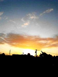 Low angle view of silhouette trees against dramatic sky