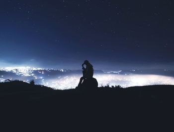 Silhouette woman standing against star field