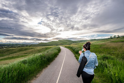 Rear view of woman walking on road at glenbow ranch provincial park