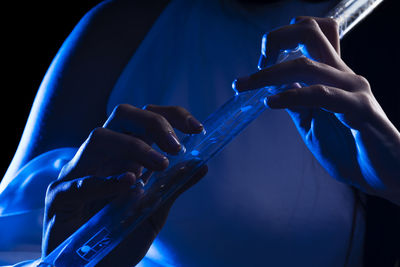 Close up of the hands of a young woman playing a crystal flute