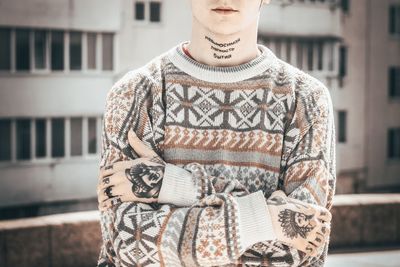 Midsection of woman standing against built structure