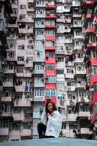 Portrait of young woman using mobile phone in city