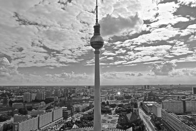 Fernsehturm in city against cloudy sky