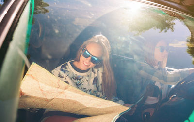 High angle view of friends traveling in car seen through windshield