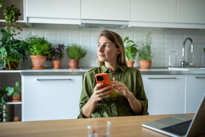 Young woman using mobile phone on table