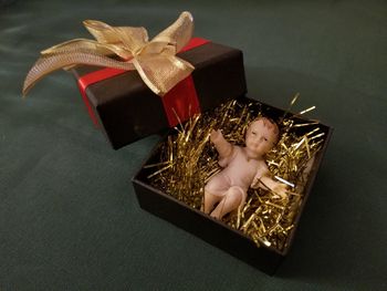 High angle view of jesus figurine with confetti in gift box