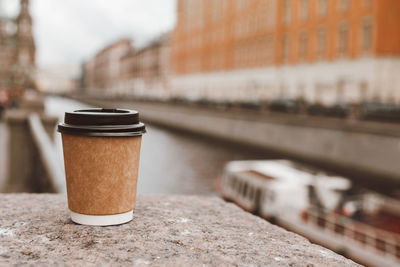 Close-up of coffee on table against building in city