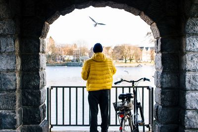 Full length rear view of woman standing by railing