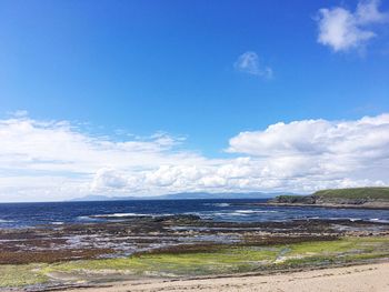 Scenic view of beach against cloudy sky