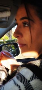 Portrait of young woman using mobile phone in car