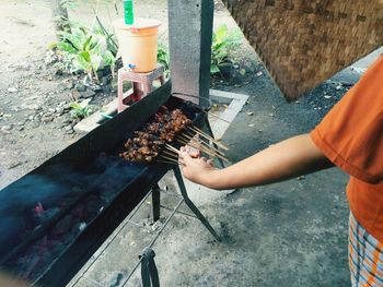 High angle view of man preparing food on barbecue grill