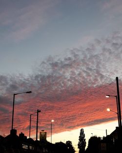 Low angle view of silhouette street light against dramatic sky