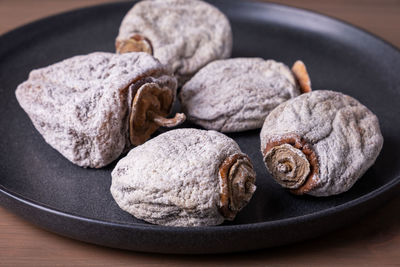 Several dried persimmons in a ceramic plate. 