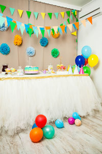 Multi colored balloons on table against wall at home