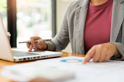 Midsection of business colleagues working at desk in office