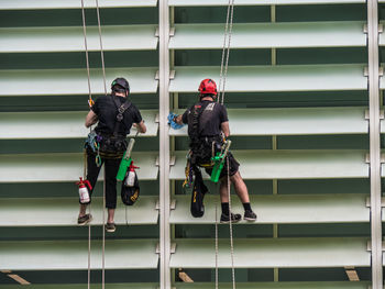 Low angle view of men cleaning building wall