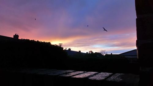 Silhouette buildings against sky during sunset