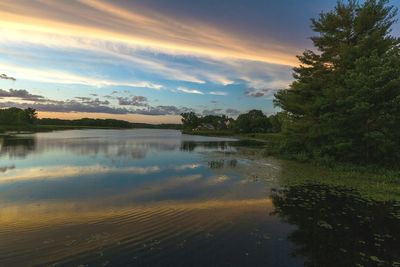 View of calm lake against cloudy sky