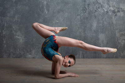 Woman lying on floor against wall