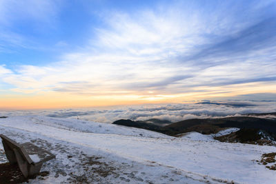 Scenic view of snow covered landscape against sky during sunset