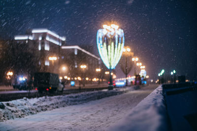 Illuminated city street during winter at night