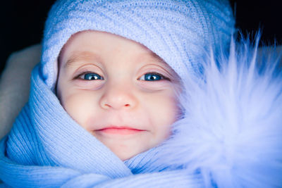 Close-up portrait of cute baby boy in purple warm clothing