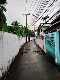 Footpath amidst buildings against sky