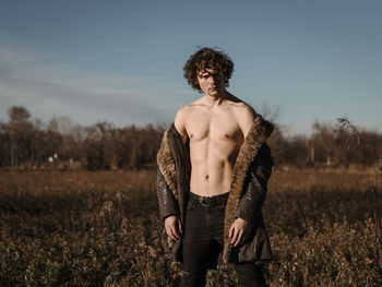 Full length of shirtless man standing on field