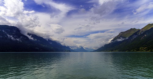 Scenic view of lake by mountains against sky