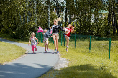 Siblings jumping over road in city