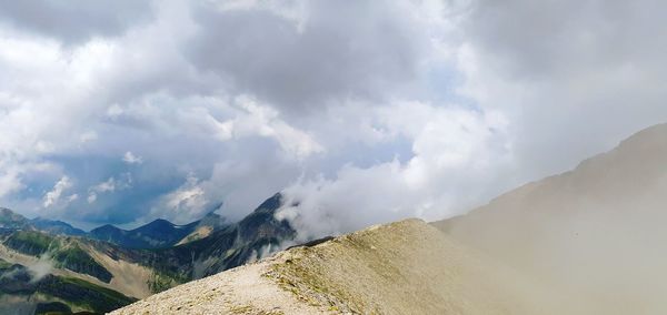 Panoramic view of mountains against cloudy sky