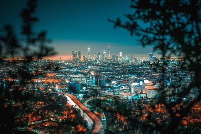 Illuminated cityscape against sky at night