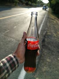 Midsection of man holding glass bottle