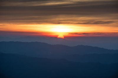 Scenic view of silhouette mountains against romantic sky at sunset