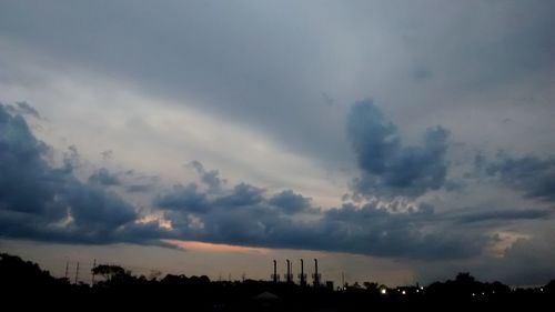 Silhouette of trees against cloudy sky