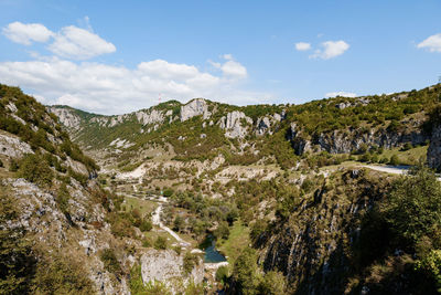 Rear view of man walking on mountain against sky