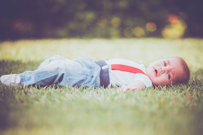 Cute boy lying on field