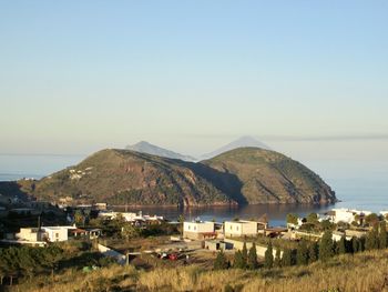 Scenic view of sea by buildings against clear sky