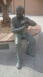 Statue of woman sitting on tiled floor