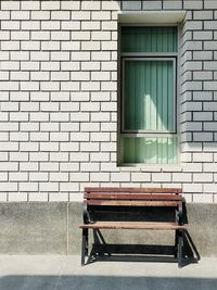 Empty bench against building