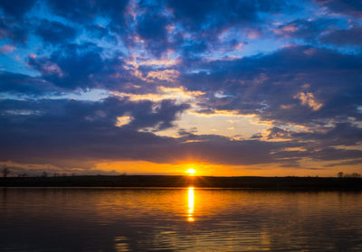 Scenic view of sea against dramatic sky during sunset