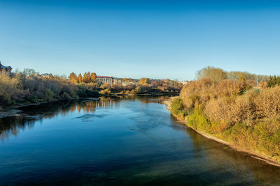 Scenic view of river against clear blue sky